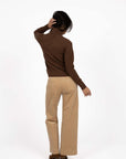 Model in studio wearing Alana Skivvy in Chocolate with Va Va Velour Pant in Camel and brown boots, full-length back view  