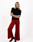 Model in studio wearing Stitched Luxe Pant in Rust with black Vera Top and black boots, full-length front view  