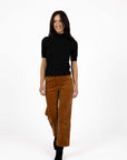 Model in studio wearing Vera Top in Black with Va Va Velour pant in Camel, full-length front view  