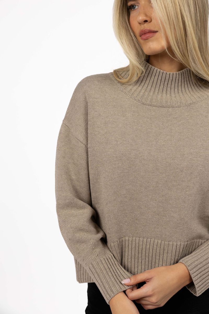 Model in studio wearing Sera Jumper in Mushroom, close-up front view showing details of the cuff, collar and hem 
