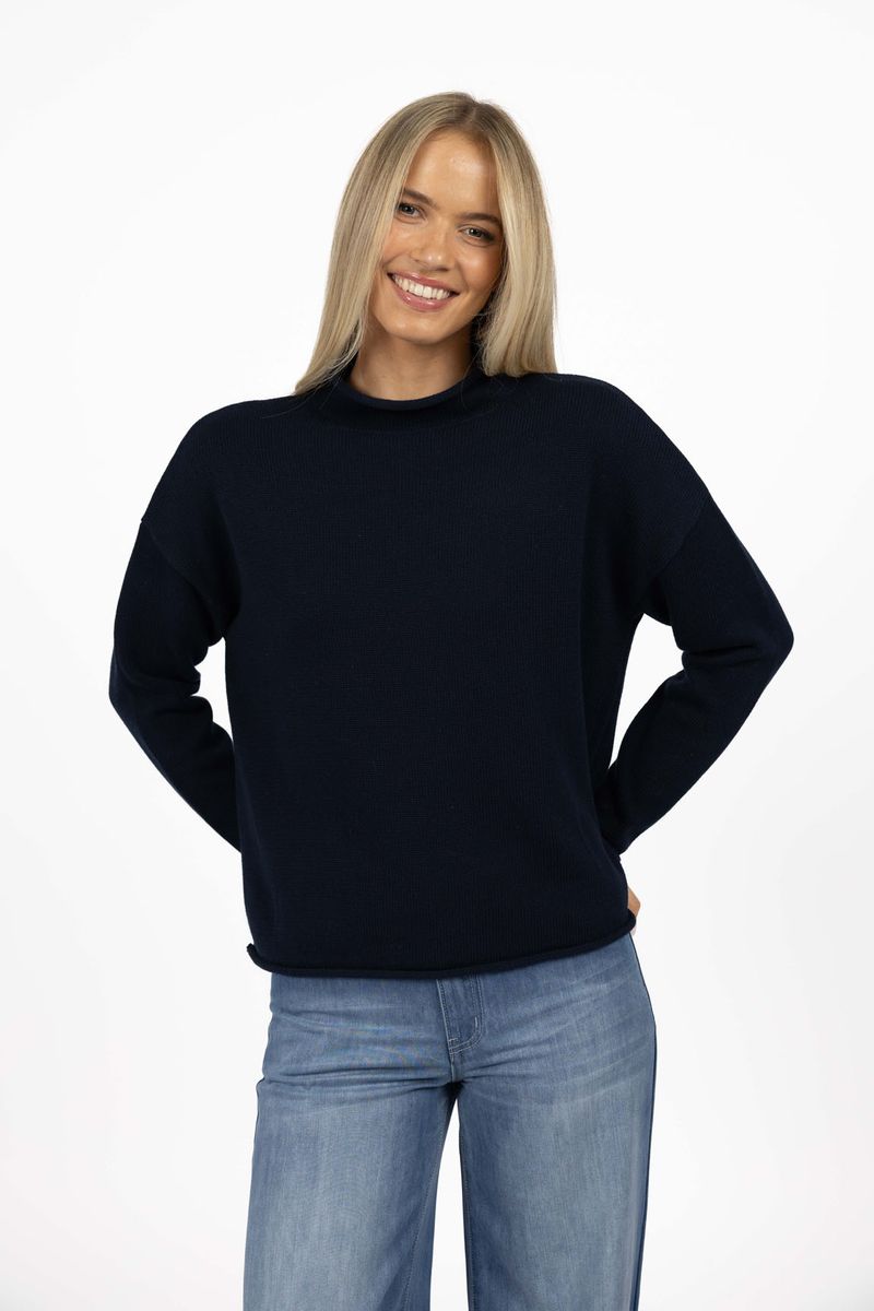 Model in studio wearing Divine Jumper in Navy with Ryder Jean, close-up front view  