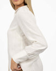 Model in studio wearing Pixie Shirt in White, close-up side view showing sleeve 