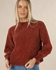 Model in studio wearing Chenille Jumper in Rust with Ryder Jean, close-up front view showing texture and ribbed hem 