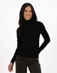 Model in studio wearing Alana Skivvy in Black with Va Va Velour Pant in Khaki, close-up front view 