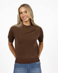 Model in studio wearing Aurora Top in Chocolate with Ryder Jean, close-up front view showing relaxed fit 