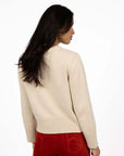 Model in studio wearing Rexie Jumper in Cream with Va Va Velour Pant in Rust, close-up back view 