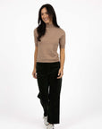 Model in studio wearing Va Va Velour Pant in Pine with Vera Top in Hazelnut with white sneakers, full-length front view  