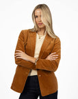 Model in studio wearing Va Va Velour Coat in Camel over Mae Jumper in Buttermilk with Escapade Jean, close-up front view 