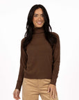 Model in studio wearing Alana Skivvy in Chocolate with Va Va Velour Pant in Camel, close-up front view  