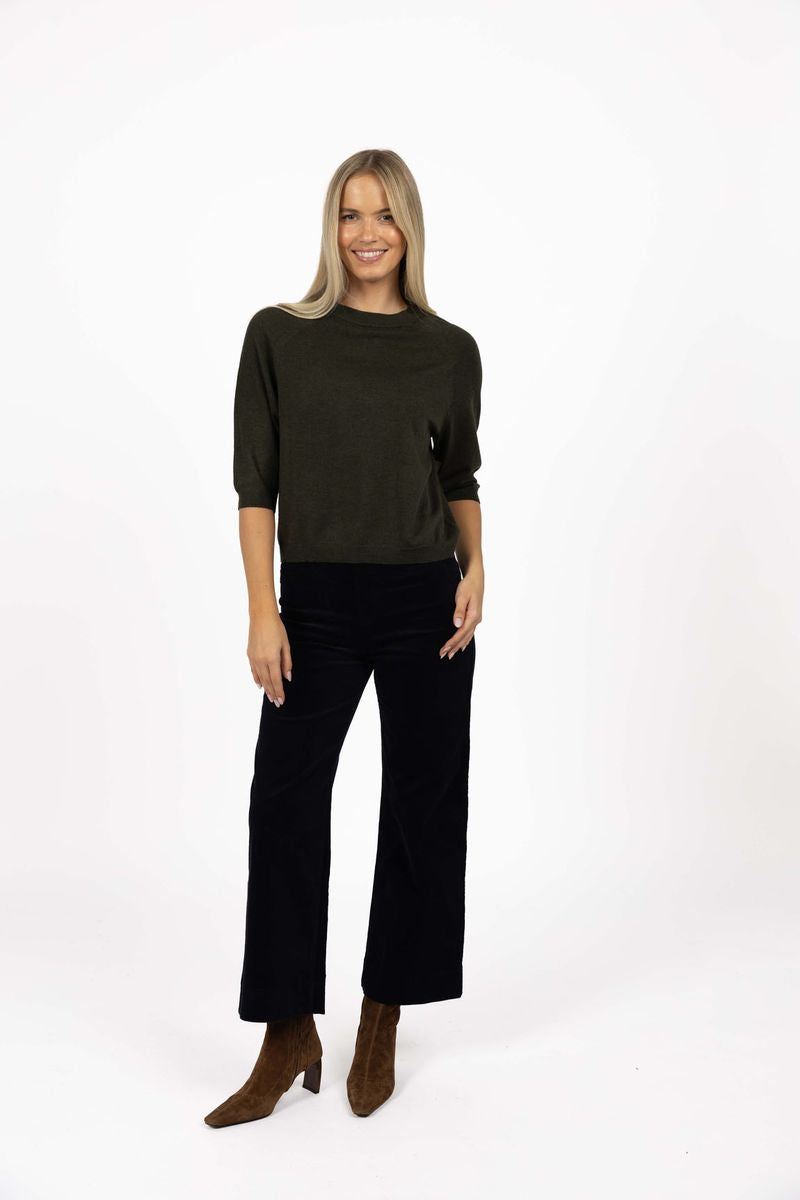 Model in studio wearing Grace Top in Moss with black Va Va Velour Pant and brown boots, full-length front view 