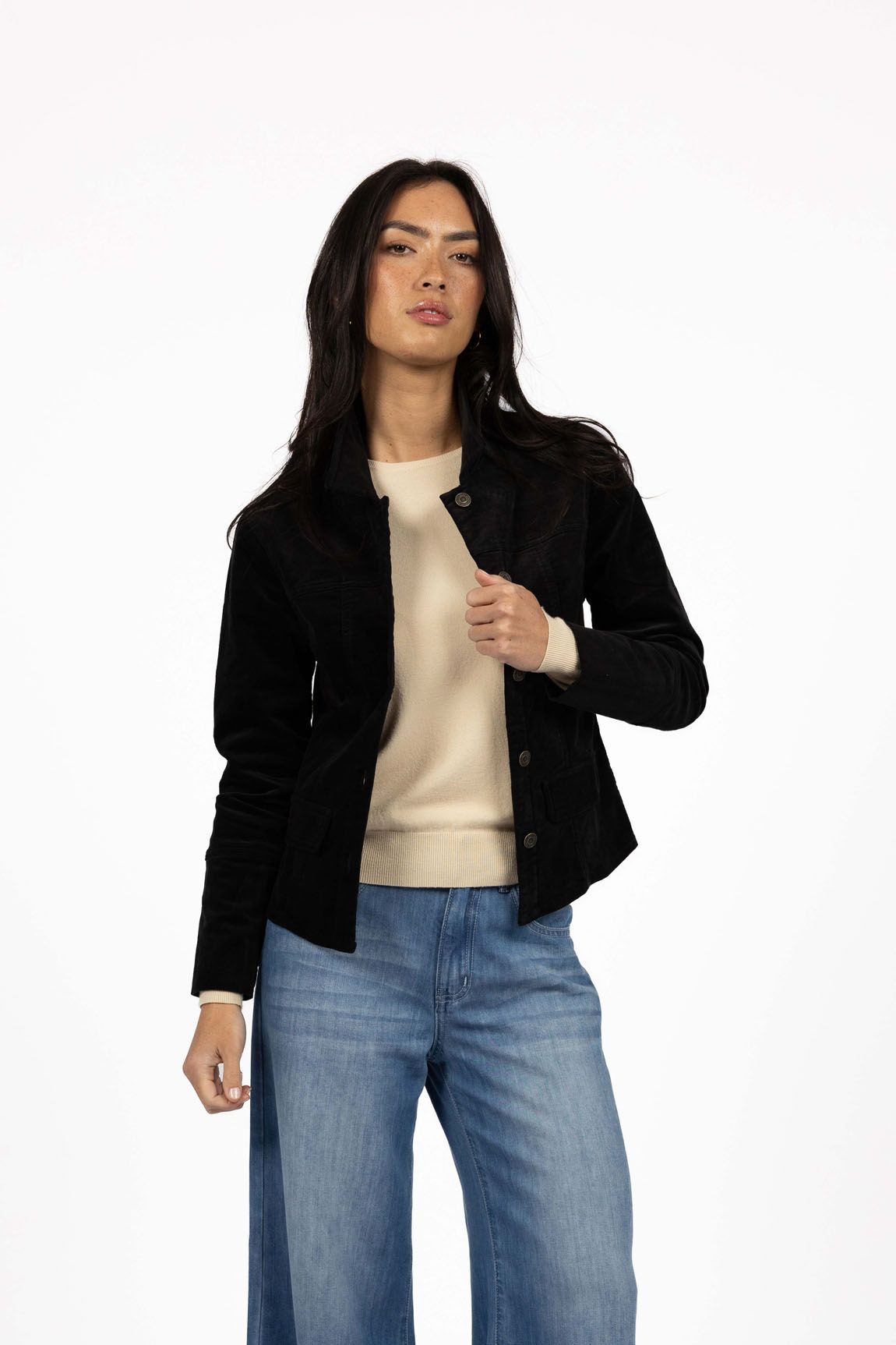 Model in studio wearing Gabi Jacket in Black over Mae Jumper in Buttermilk and Ryder Jean, close-up front view 