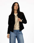 Model in studio wearing Gabi Jacket in Black over Mae Jumper in Buttermilk and Ryder Jean, close-up front view 