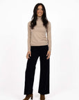Model in studio wearing Alana Skivvy in Birch with Va Va Velour Pant in Black and brown boots, full-length front view  