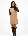Model in studio wearing Nova Cord Dress in Wheat over the Alana Skivvy in Chocolate with brown boots, full-length front view  