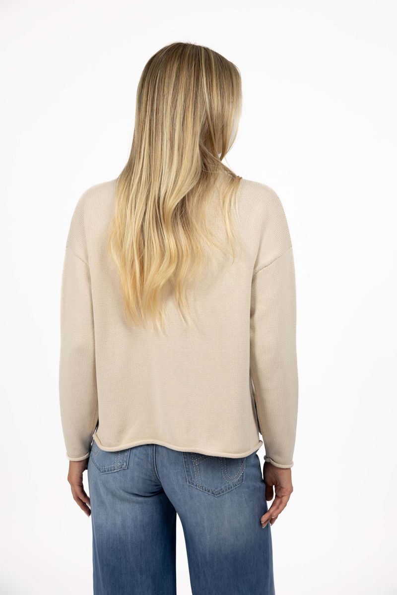Model in studio wearing Divine Jumper in Stone with Ryder Jean, close-up back view  