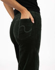 Model in studio wearing Stitched Luxe Pant in Pine with black Vera Top, close-up back view showing pocket embroidery 