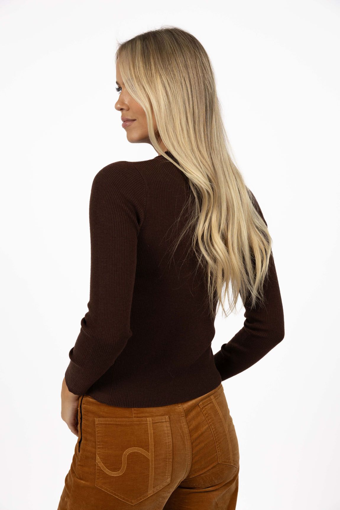 Model in studio wearing Tempo Top in Chocolate with Stitched Luxe Pant in Camel, close-up back view 
