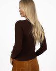Model in studio wearing Tempo Top in Chocolate with Stitched Luxe Pant in Camel, close-up back view 