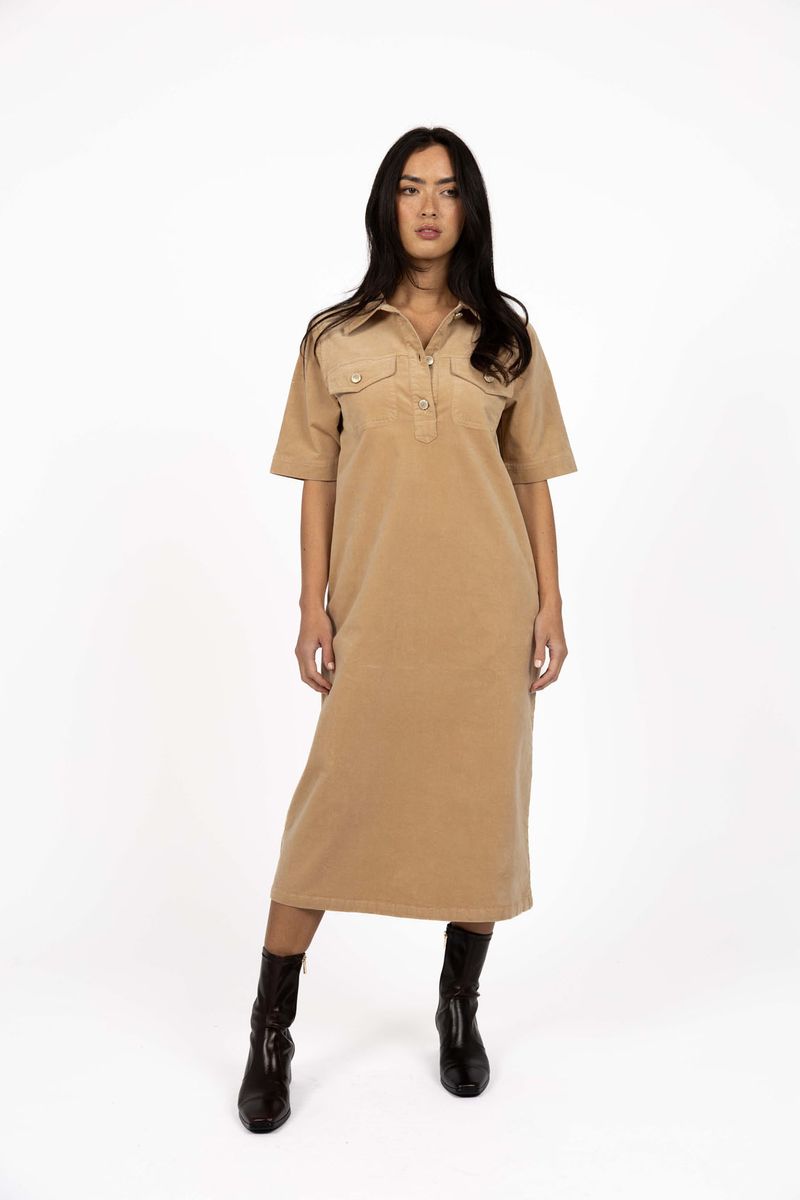 Model in studio wearing Amici Cord Dress in Wheat with brown boots, full-length front view  