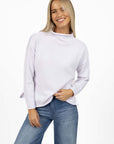 Model in studio wearing Divine Jumper in White with Ryder Jean, close-up front view 