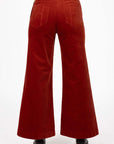 Model in studio wearing Stitched Luxe Pant in Rust with black boots, close-up back view showing pocket embroidery  