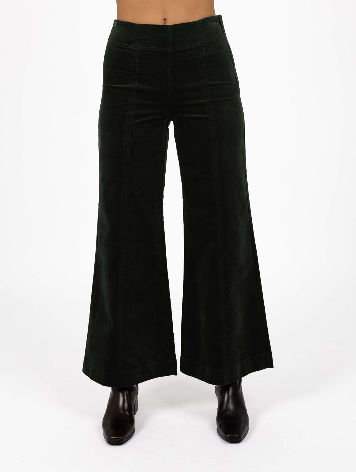 Model in studio wearing Stitched Luxe Pant in Pine with black boots, close-up front view showing mid-rise and wide leg  