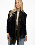 Model in studio wearing Va Va Velour Coat in Navy over white tee with Ryder Jean and Motif Scarf, close-up front view