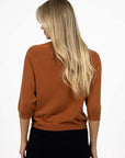 Model in studio wearing Grace Top in Caramel with black Va Va Velour Pant, close-up back view 