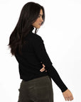 Model in studio wearing Alana Skivvy in Black with Va Va Velour Pant in Khaki, close-up back view 