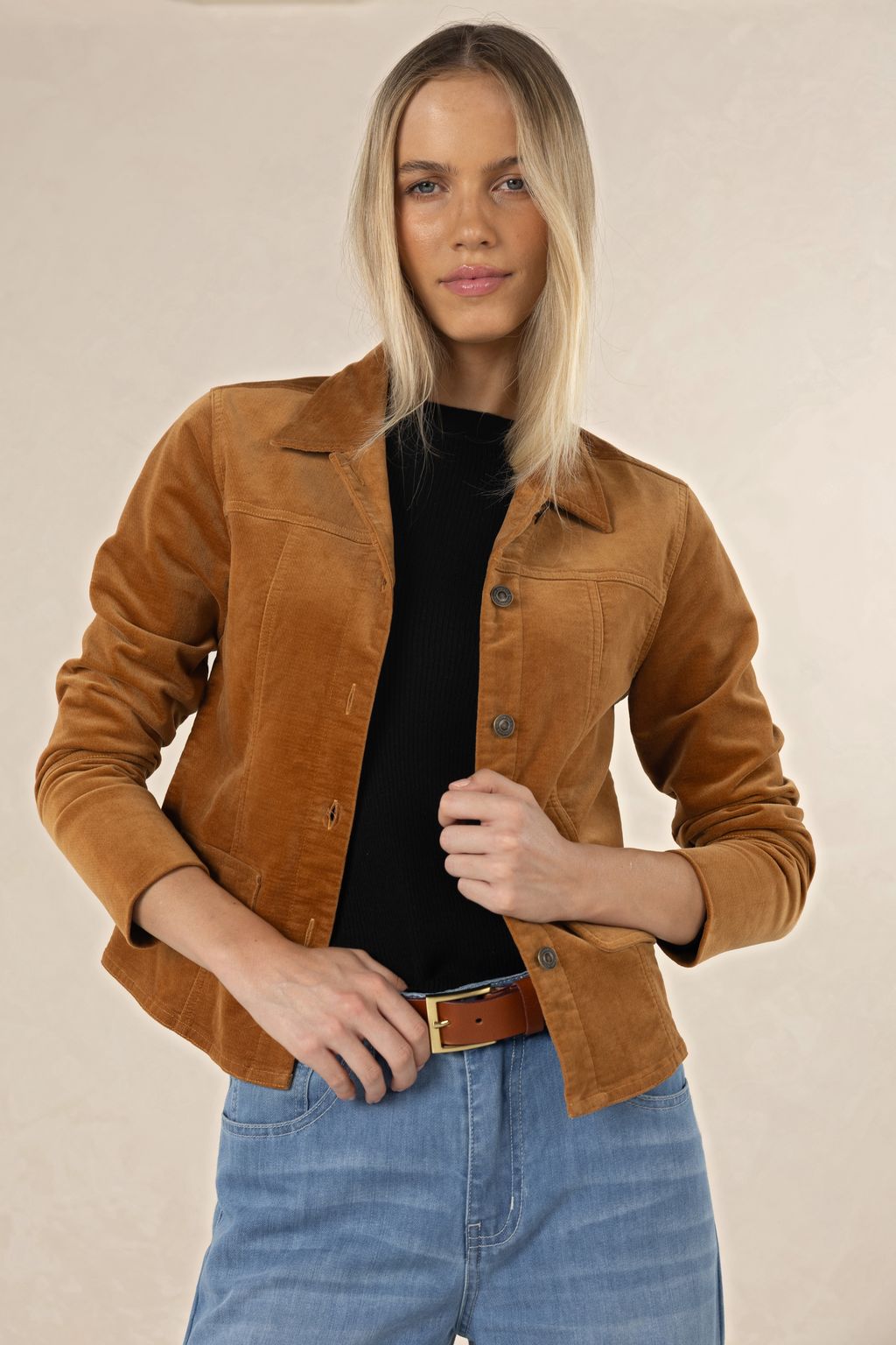 Model in studio wearing Gabi Jacket in Camel over black tee and Ryder Jean with tan Classic Belt, close-up front view 
