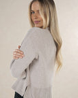 Model in studio wearing Chenille Jumper in Light Grey, close-up back view looking over shoulder 