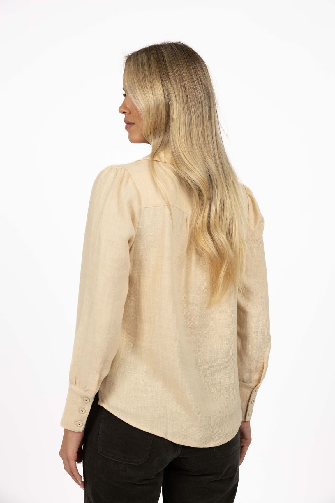 Model in studio wearing Pixie Shirt in Sand with Fleetwood Cord Pant in Khaki, close-up back view showing round hem 