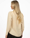 Model in studio wearing Pixie Shirt in Sand with Fleetwood Cord Pant in Khaki, close-up back view showing round hem 