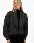 Model in studio wearing Liana Cardi in Charcoal over black skivvy, close-up front view with arms by side  