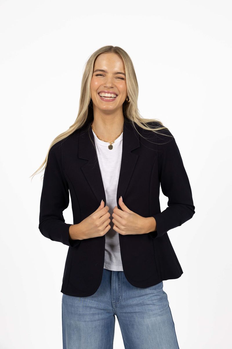Model in studio wearing Roca Jacket in Navy over white tee with Ryder Jean, close-up front view 