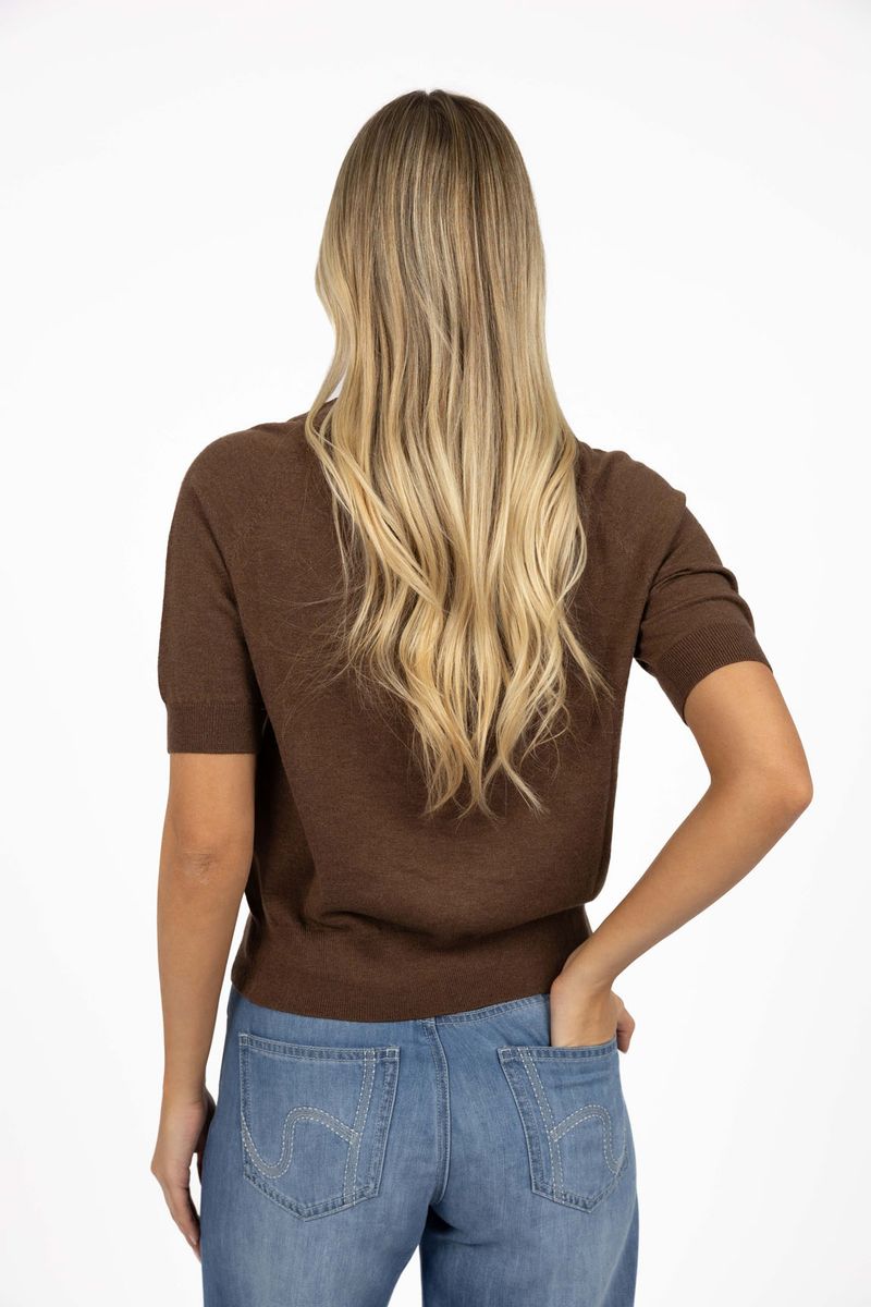 Model in studio wearing Aurora Top in Chocolate with Ryder Jean, close-up back view with one hand in back jean pocket  