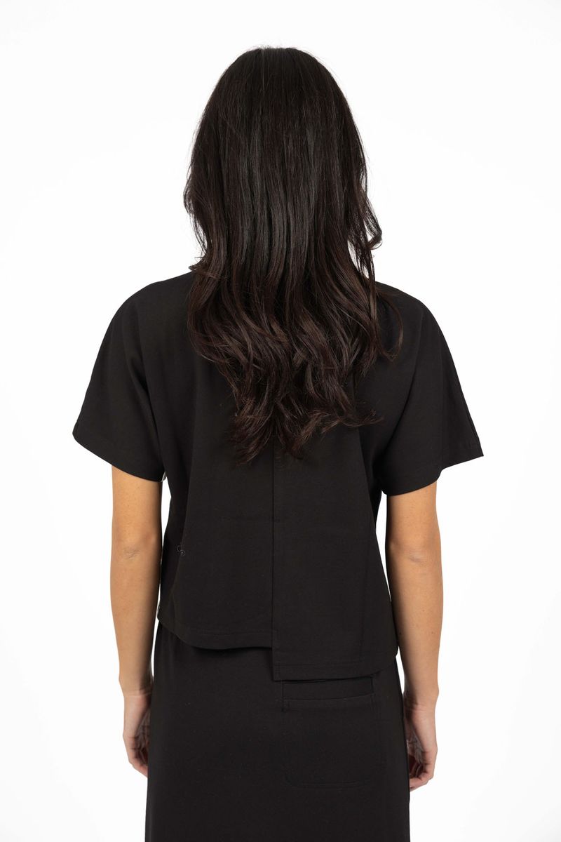 Model in studio wearing Mosh Top in Black with matching Roca Skirt, close-up back view 
