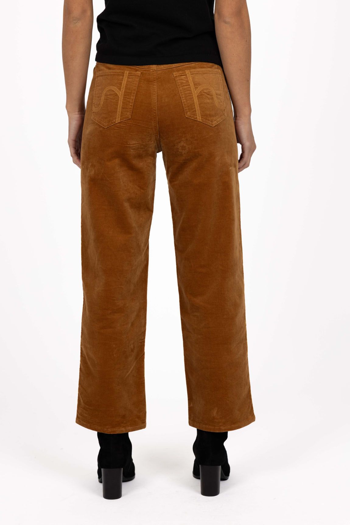 Model in studio wearing Va Va Velour Pant in Camel with black boots, close-up back view showing pocket embroidery 