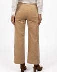 Model in studio wearing Fleetwood Cord Pant in Wheat with Pixie Shirt in White and brown boots, close-up back view 