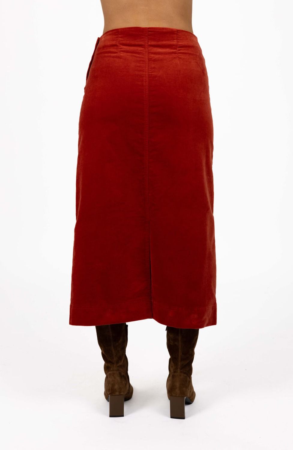 Model in studio wearing Va Va Velour skirt in Rust and brown boots, close-up back view showing straight silhouette and vent  