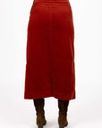 Model in studio wearing Va Va Velour skirt in Rust and brown boots, close-up back view showing straight silhouette and vent  