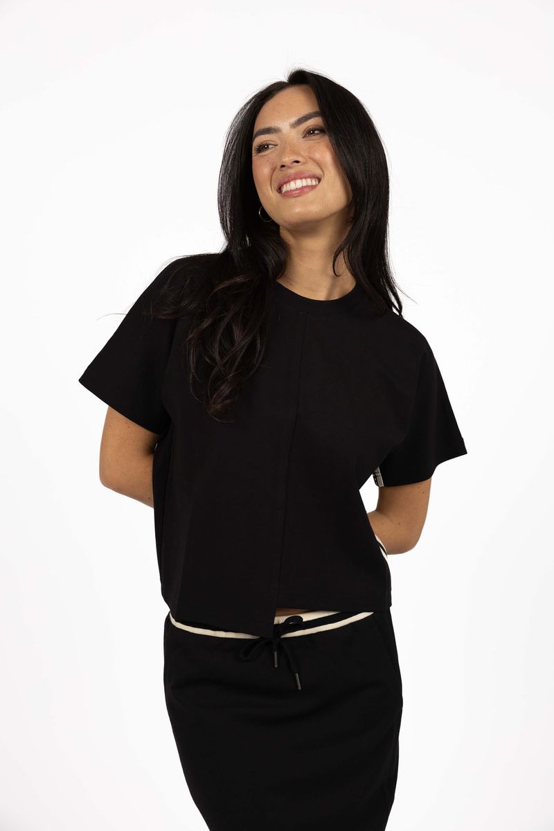 Model in studio weairng Mosh Top in Black with matching Roca Skirt, close-up front view  