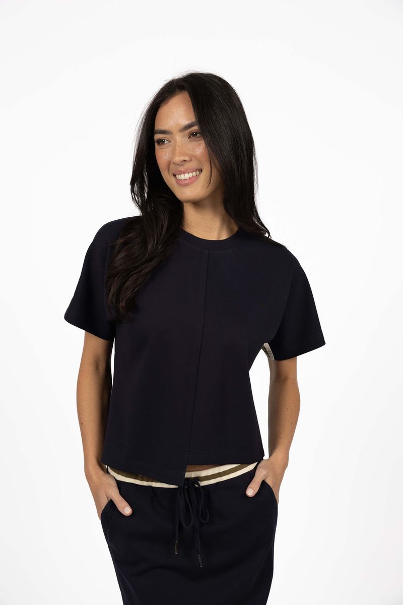 Model in studio wearing Mosh Top in Navy with matching Roca Skirt, close-up front view  
