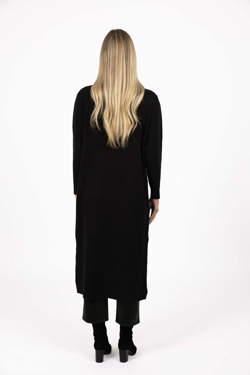 Model in studio wearing Clover Cardi in Black over Vera Top in Hazelnut and Va Va Velour Pant in Pine with black boots, full-length back view 