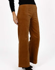 Model in studio wearing Stitched Luxe Pant in Camel with Tempo Top in Black and black boots, close-up front view showing stitch lines  