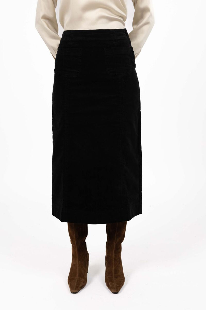 Model in studio wearing Va Va Velour Skirt in Black with brown boots, close-up front view showing midi length 
