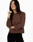 Model in studio wearing Rexie Jumper in Mocha with Va Va Velour Pant in Black, close-up front view 
