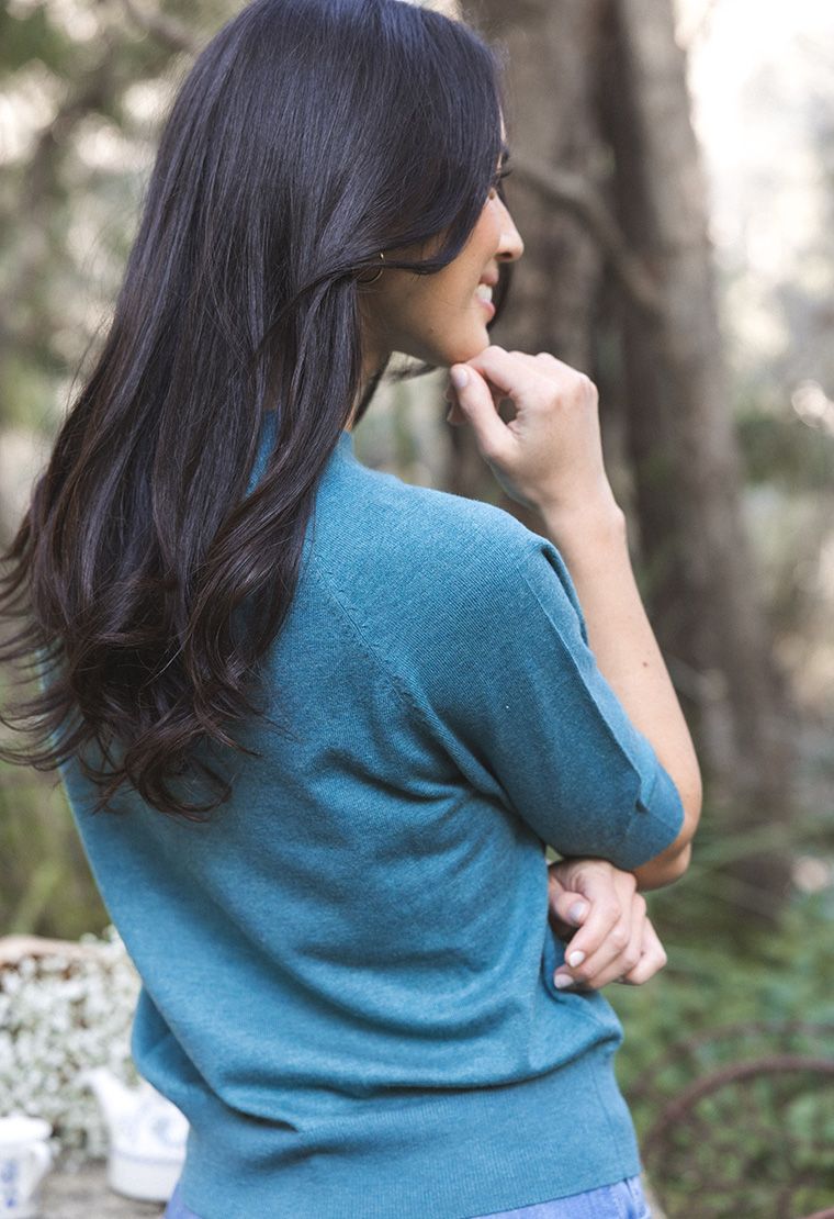 Model in lifestyle setting wearing Aurora Top in Turquoise, close-up back view with nature background 
