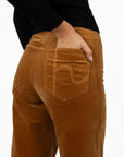 Model in studio wearing Stitched Luxe Pant in Camel with Tempo Top in Black, close-up back view showing pocket embroidery  