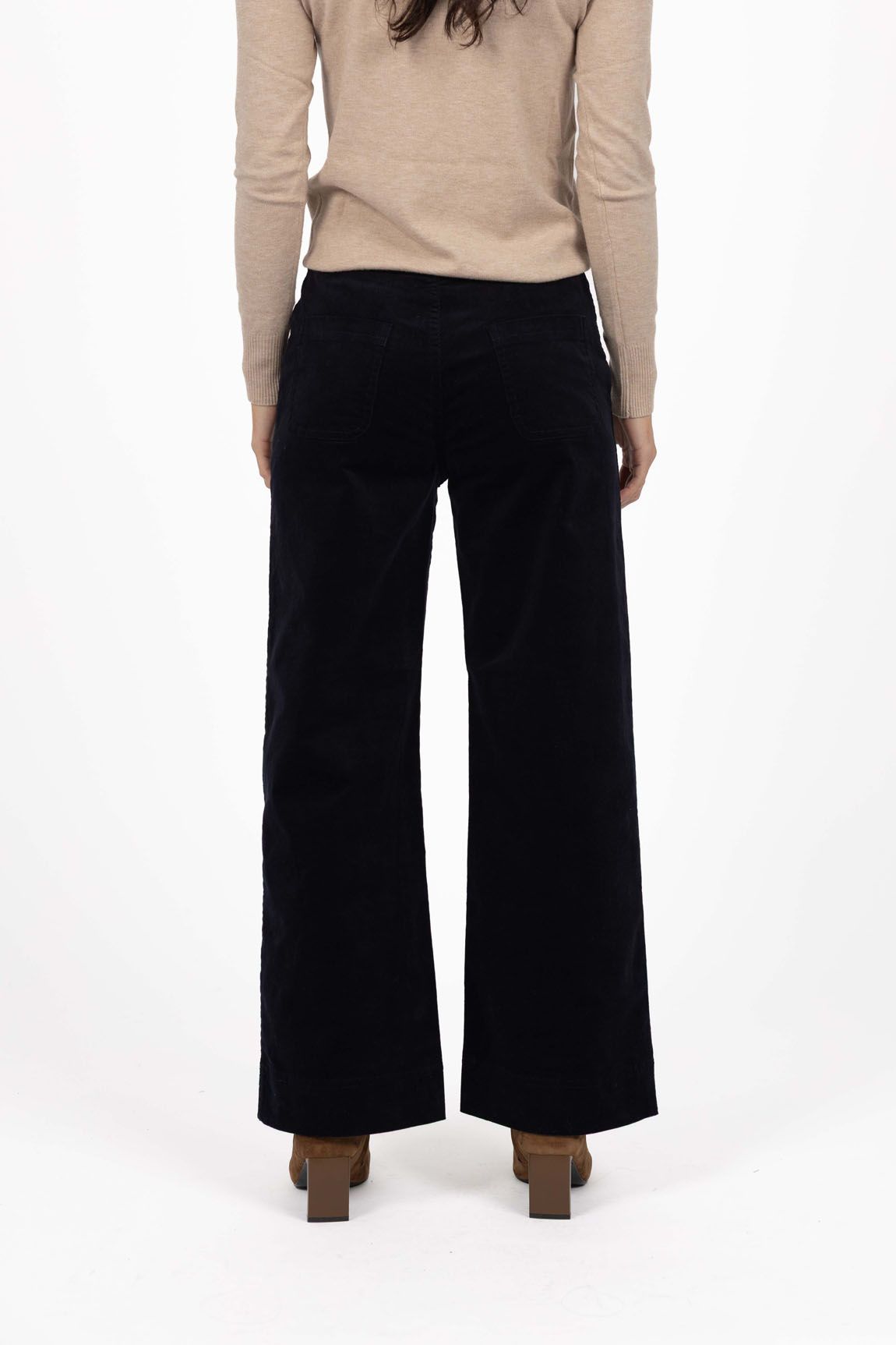 Model in studio wearing Fleetwood Cord Pant in Indigo with Alana Skivvy in Birch with brown boots, close-up back view 